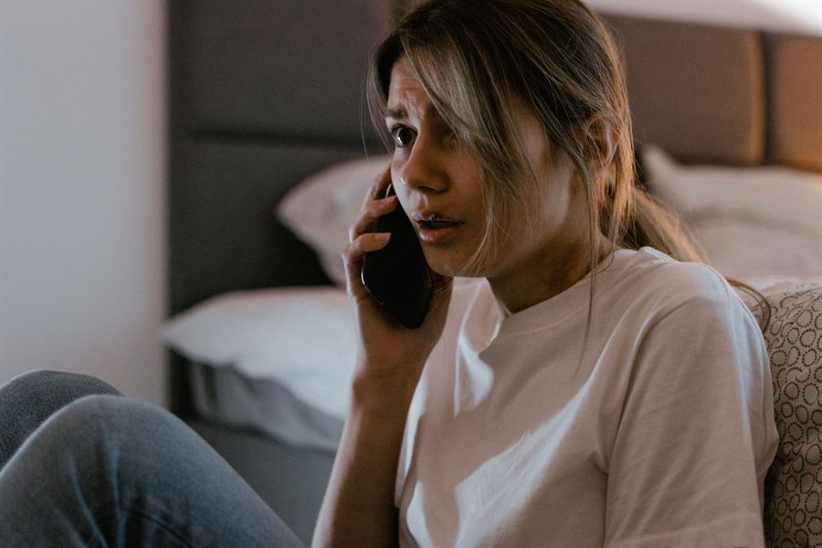 Young woman looking concerned during a phone call at home