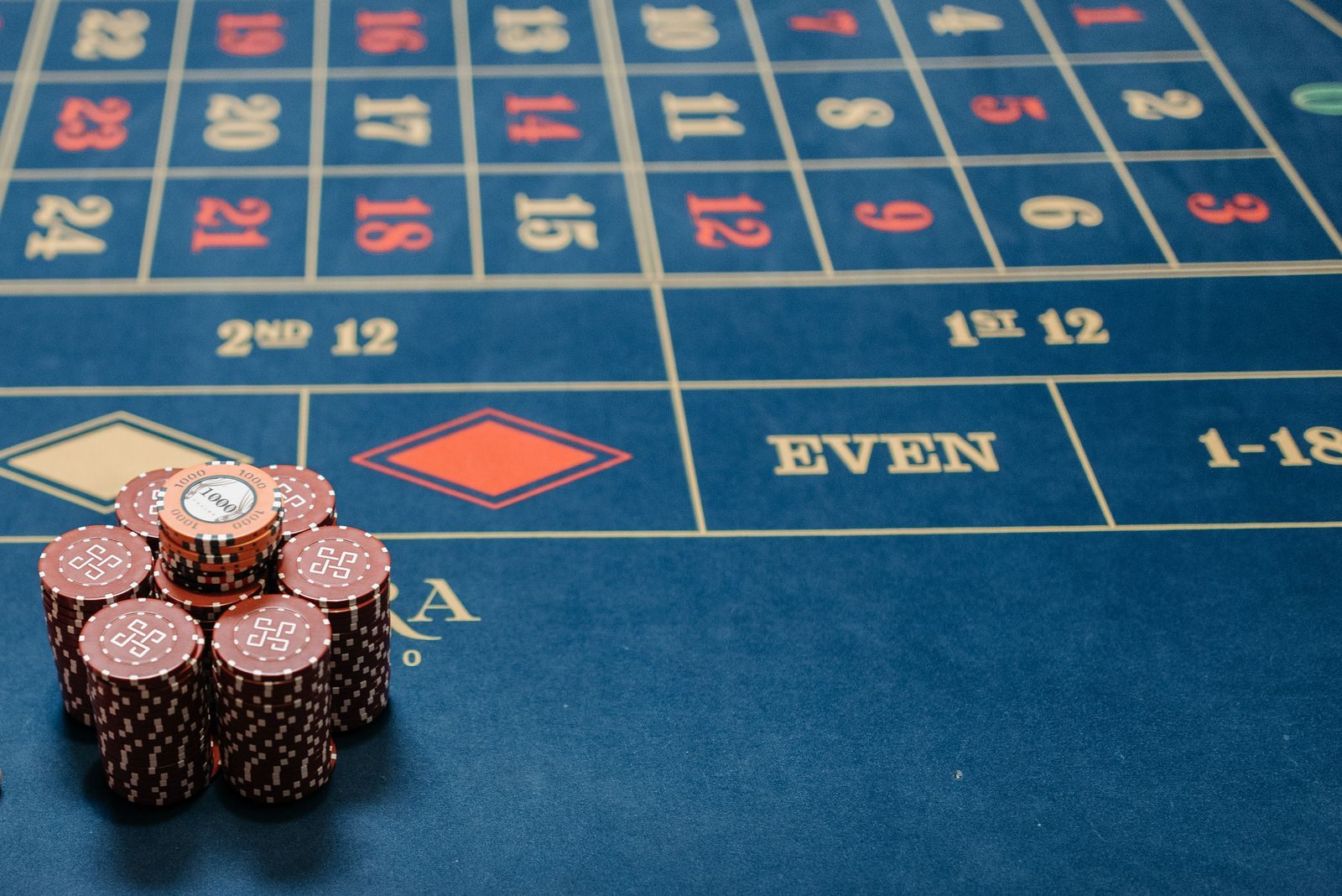 Stacked chips on a blue roulette table layout, the table play behind casino cruise offers