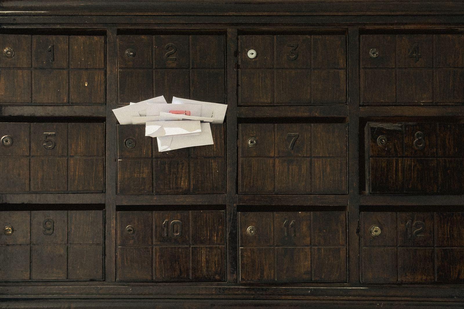 Old wooden mailboxes with letters tucked in one slot, like a free cruise offer arriving by mail