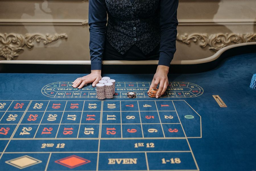 Croupier arranging chips on a roulette table