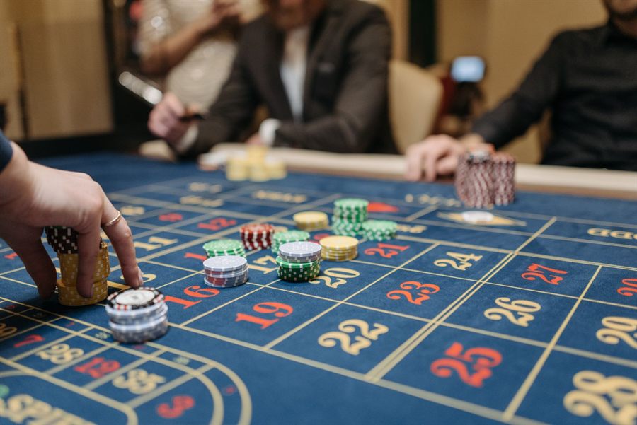 Hands placing betting chips on a roulette table