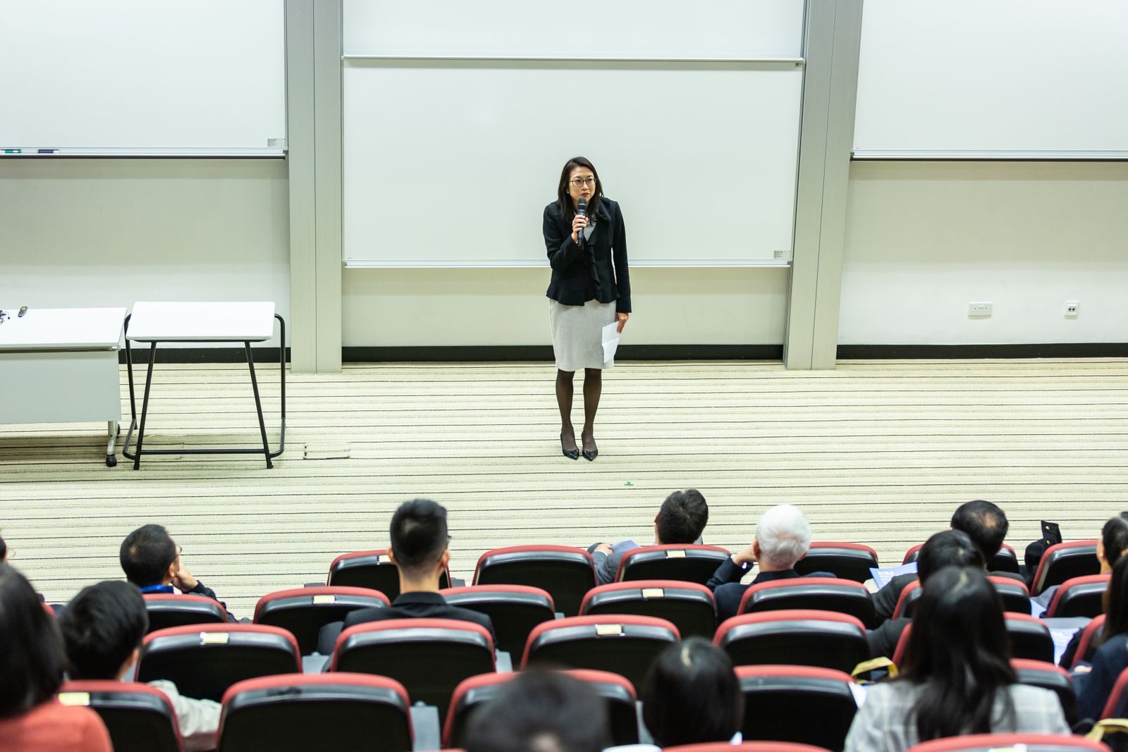 Speaker presenting to an audience in a lecture hall, like a guest lecturer who gets to cruise for free